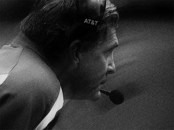 A coach on the sideline wearing a headset